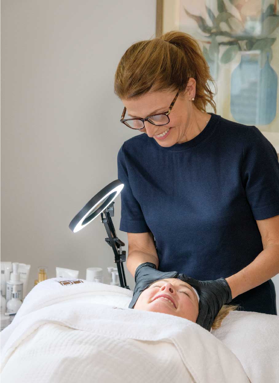 skin therapist performing facial treatment